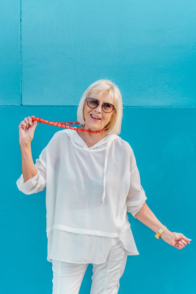 Smiling trendy older female in hood