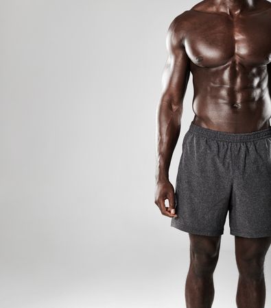 Cropped shot of young muscular man body against grey background
