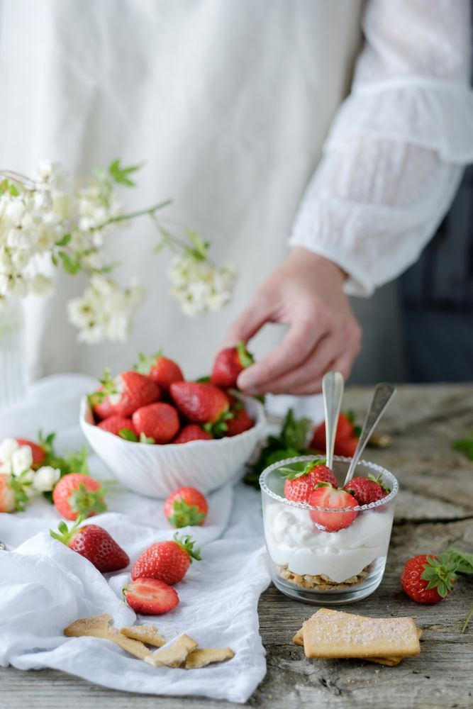 Confectioner cooking dessert of ripe strawberries