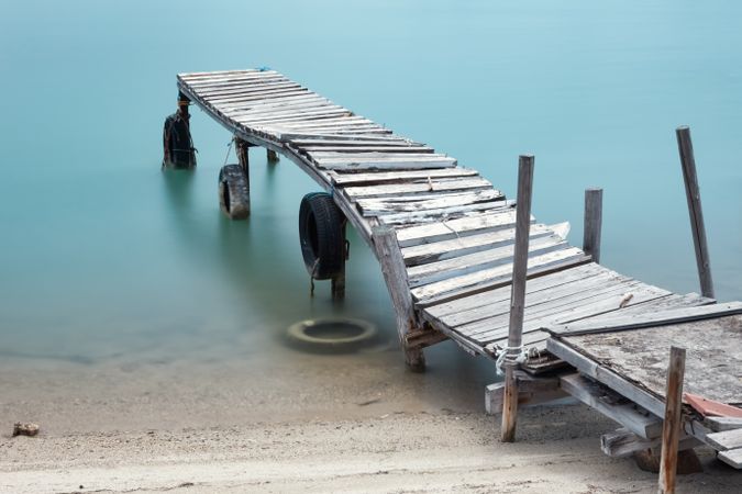 Wooden broken old pier in calm water