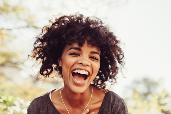 Close up of young woman with curly hair laughing