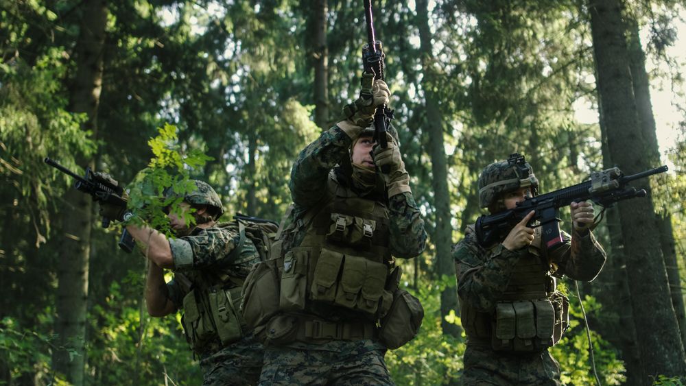 Three Fully Equipped Soldiers Wearing Camouflage Uniform Attacking Enemy, They're in Shooting Ready Stance
