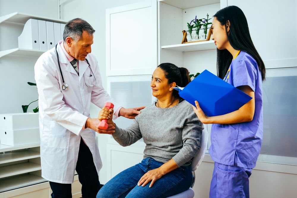 Doctor and physiotherapist helping patient work through arm rehab exercises
