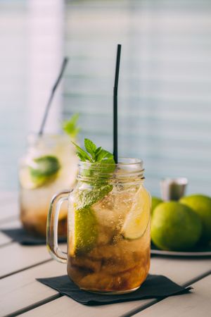 two Mojitos in mason jar on wooden table