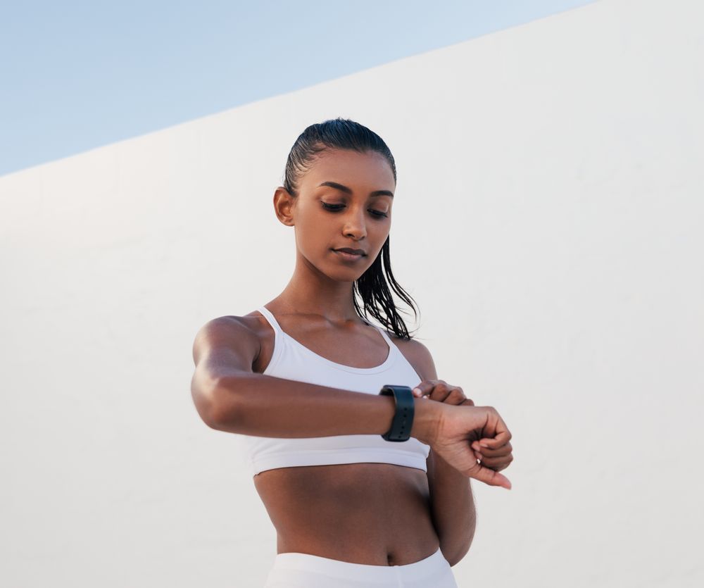 Fit woman checking watch while working out