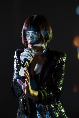 Stylish woman singing on stage