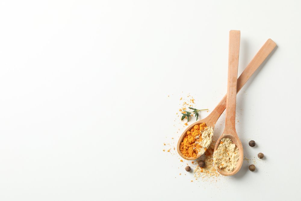Top view of two wooden spoons full of spice, copy space