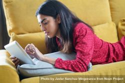 Female relaxing at home while reading on a tablet 5rQ9d0