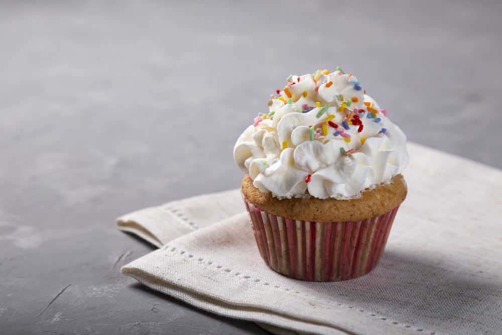 Tasty party cupcakes on the table. Cupcakes with whipped cream.