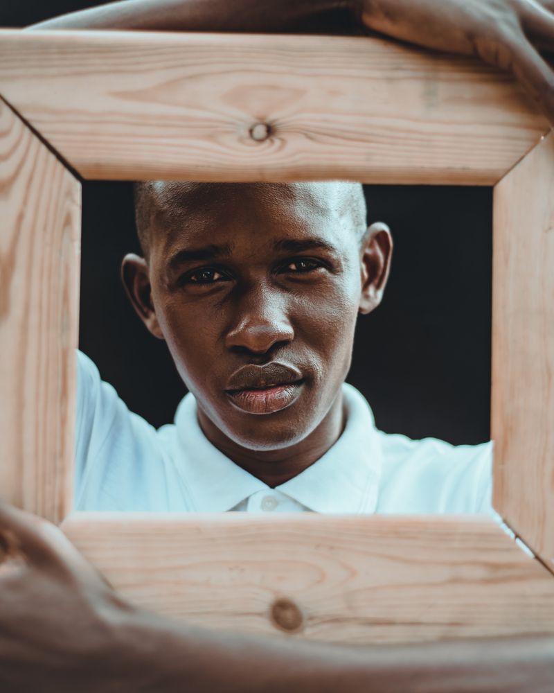 Boy behind wooden frame
