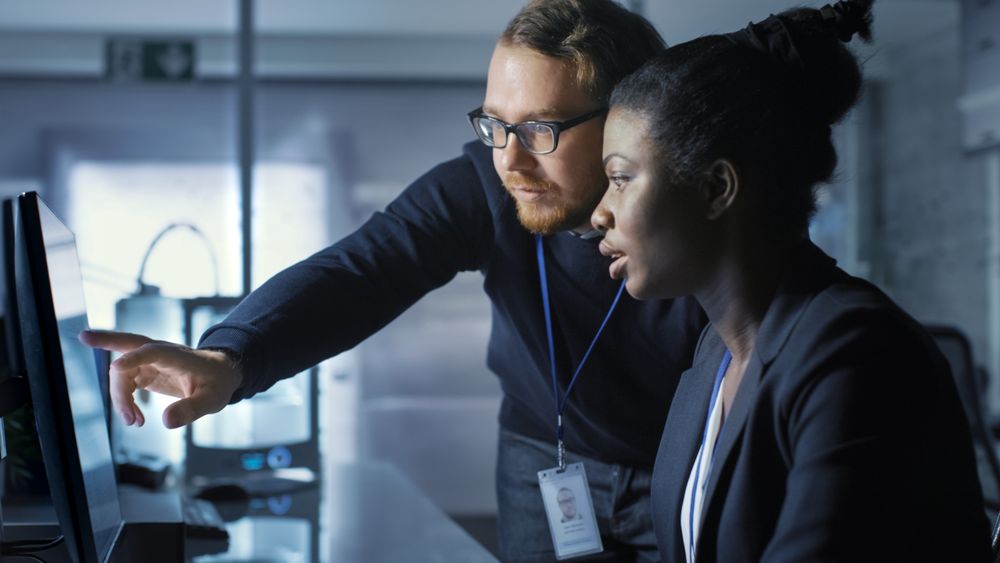 Female Scientist Works on a Computer and Having Discussion with Male Colleague.