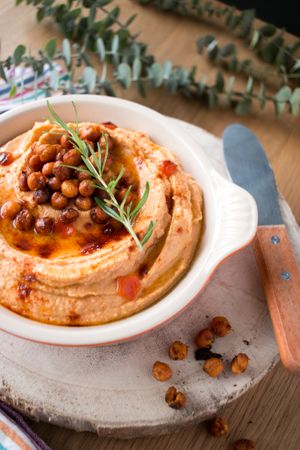 Rosemary sprig on pepper hummus