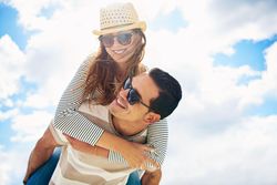 Woman smiling on her boyfriend’s back