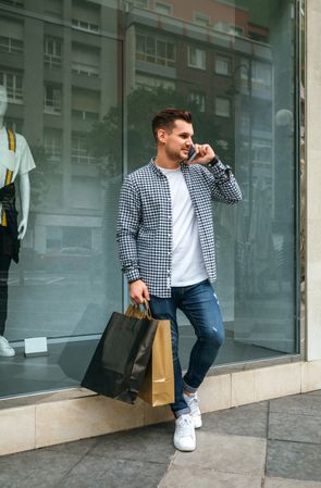 Young man with shopping bags and mobile