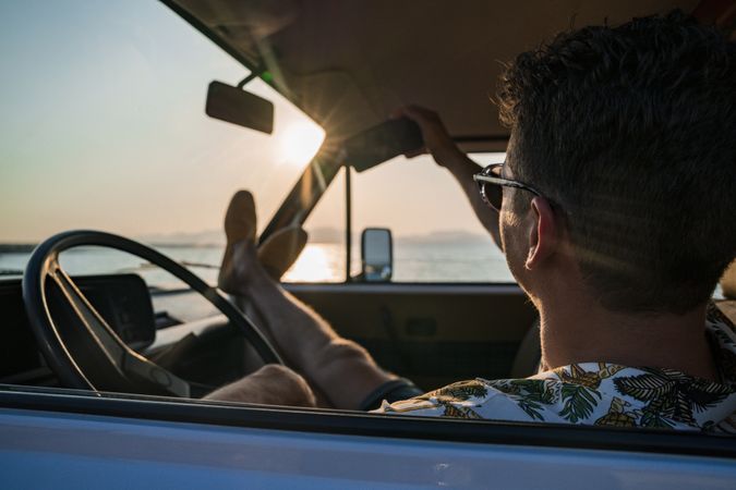 Happy adult man taking selfie with smartphone while sitting in van