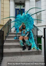 Young Black woman with large elaborate blue feathered headdress and costume at Notting Hill Carnival 5oDrx4