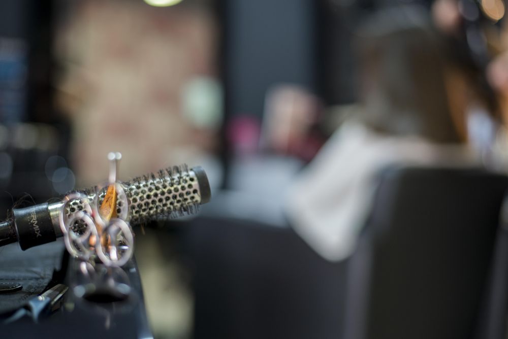 Hair stylist scissors and ceramic curler brush with selective focus