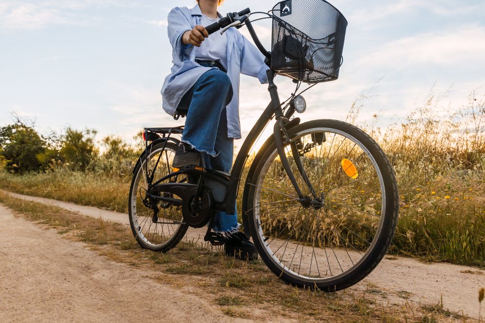 woman on a bike in a field. sunset