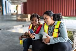 Women in high visibility vests sitting and taking a break from work