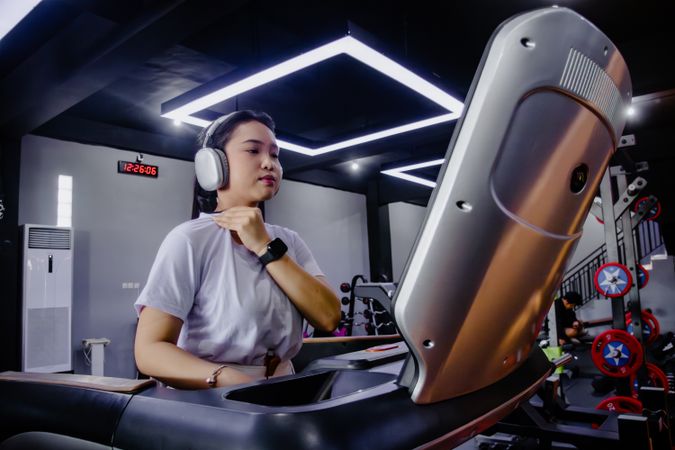 Determined woman exercising on treadmill in modern gym setting
