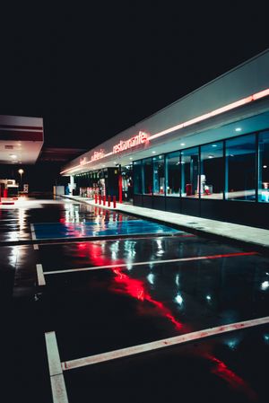 Empty retro gas station with cafe at night after rain
