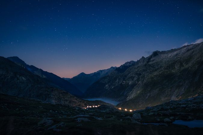 Lights above river in silent mountains at dusk