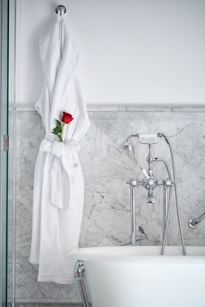 Interior of bathroom with bathrobe with fresh red rose