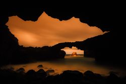 Amazing cave near water and blue sky