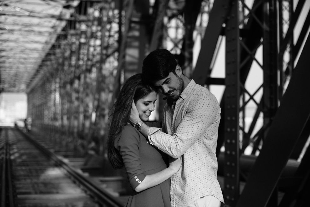 Amorous couple bonding on railway under bridge