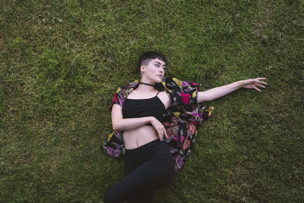 Woman in colored shirt lying on grass