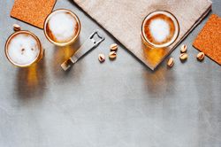 Top view of beer on wooden table with bottle opener and pistachios