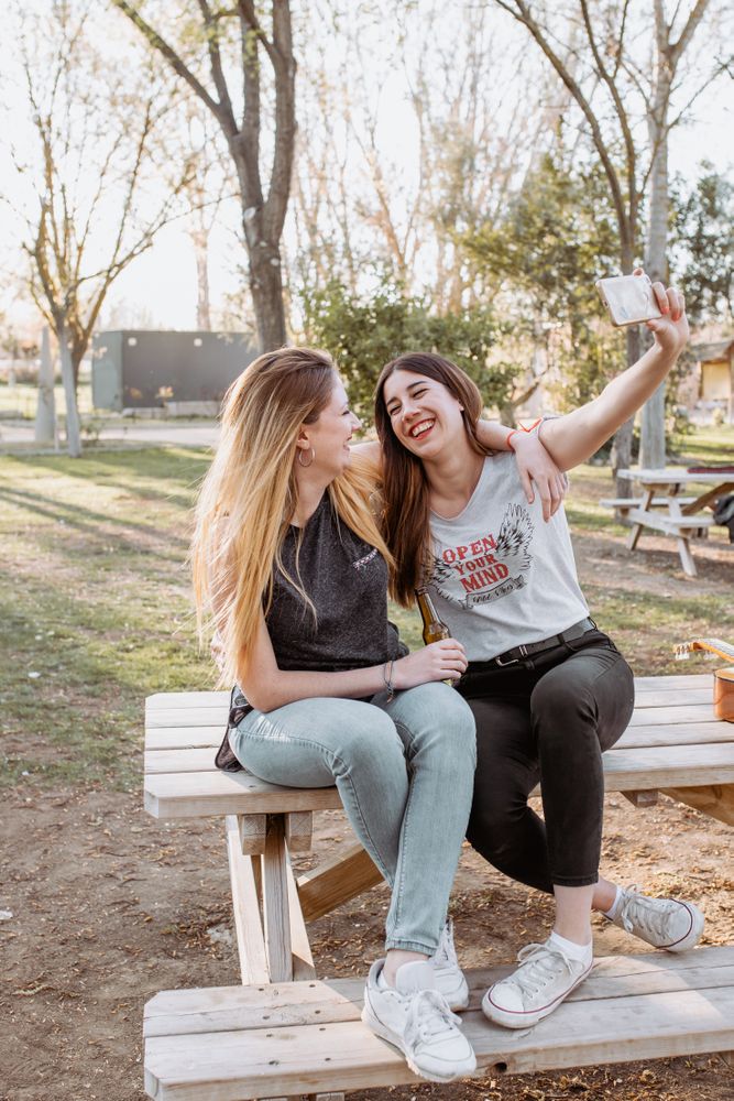 Smiling women taking selfie in park