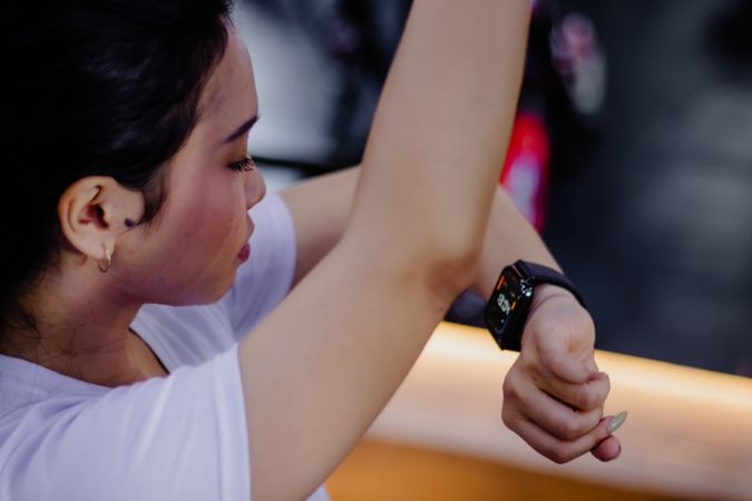 Fitness Focused Woman Checking Smartwatch During Workout Session
