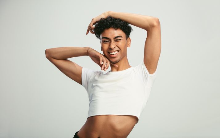 Portrait of a man wearing crop top winking at camera