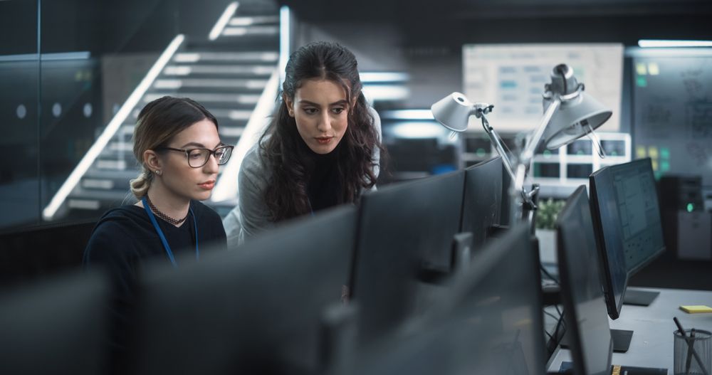 Young Female Software Developer Working on Computer Together with a Friendly Colleagues.