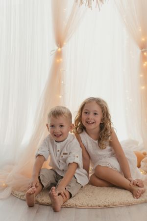 Sister embracing little brother at home