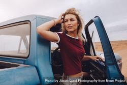 Woman standing besides her car and looking back 5nJMm5