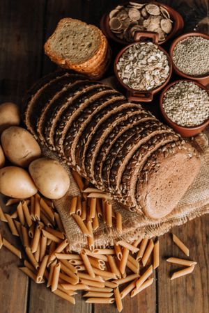 Wholegrain food pasta and freshly baked rye bread on table