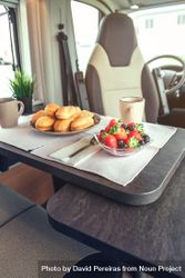 Breakfast pastries, coffee and bowl of berries in camper van, vertical 0LG2Eb