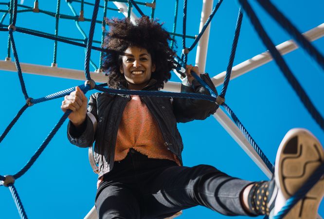 Woman with afro hair climbing by children's attractions.