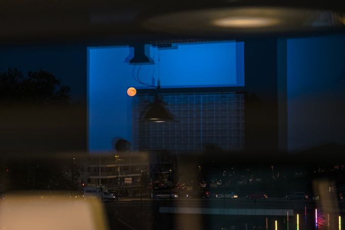 City lights and moon through office windows at night