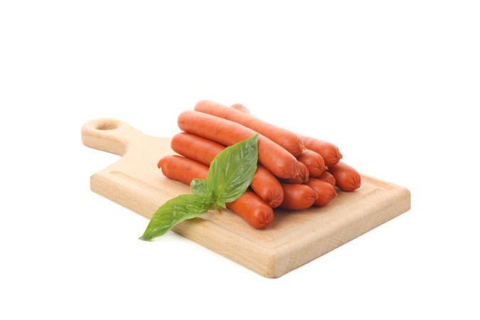 Sausage links on wooden board with garnish