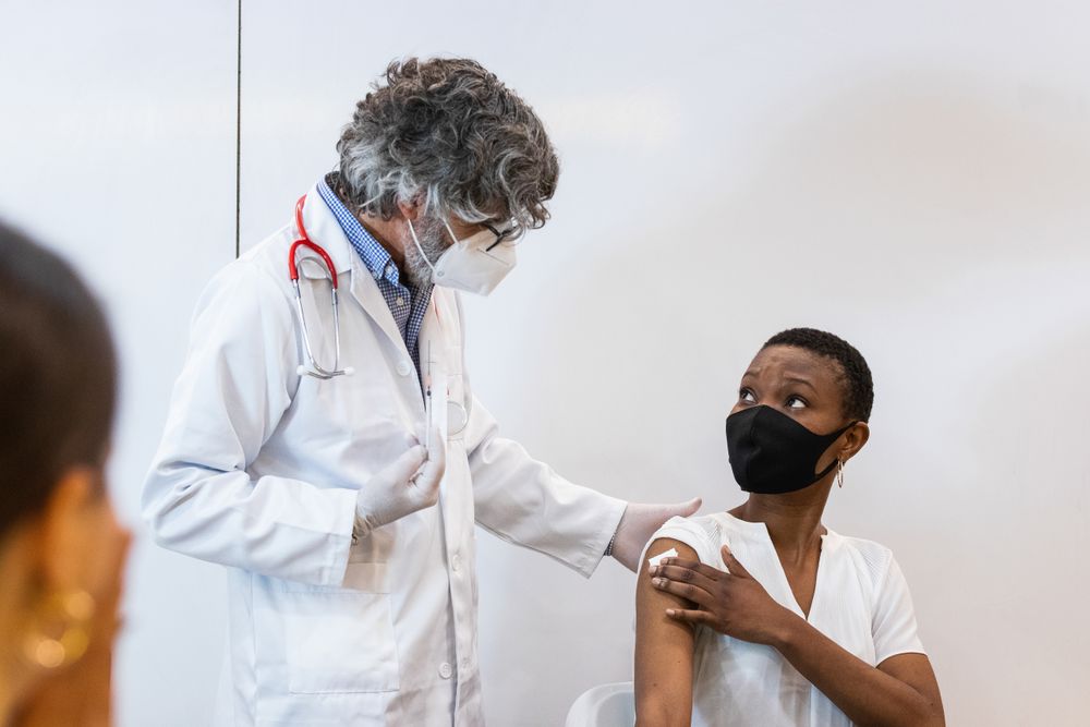 Doctor making injection for black woman patient