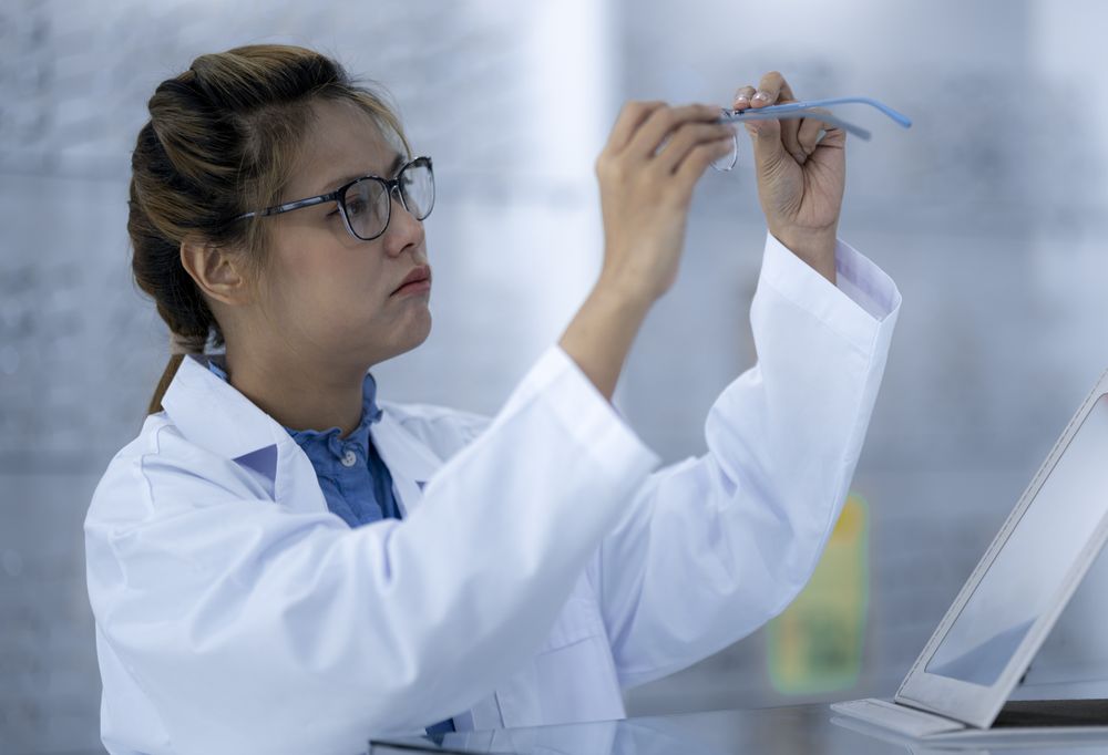An ophthalmologist is checking the glasses before delivering them.