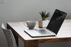 Silver Laptop Computer Next to Ceramic Cup