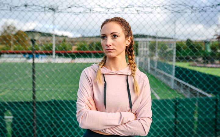 Serious sportswoman with boxer braids posing with crossed arms