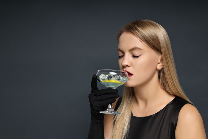 A girl at a party in the style of Halloween with a cocktail in her hands
