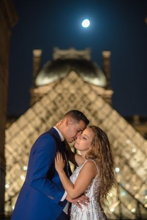 Just married couple in wedding clothing cuddling under moonlight