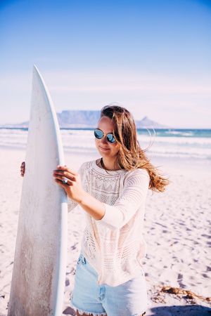 Young woman holding a surfboard at the beach