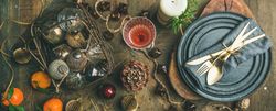 Top view of table setting with crystal flute of Champagne, pinecone, and candle, wide composition